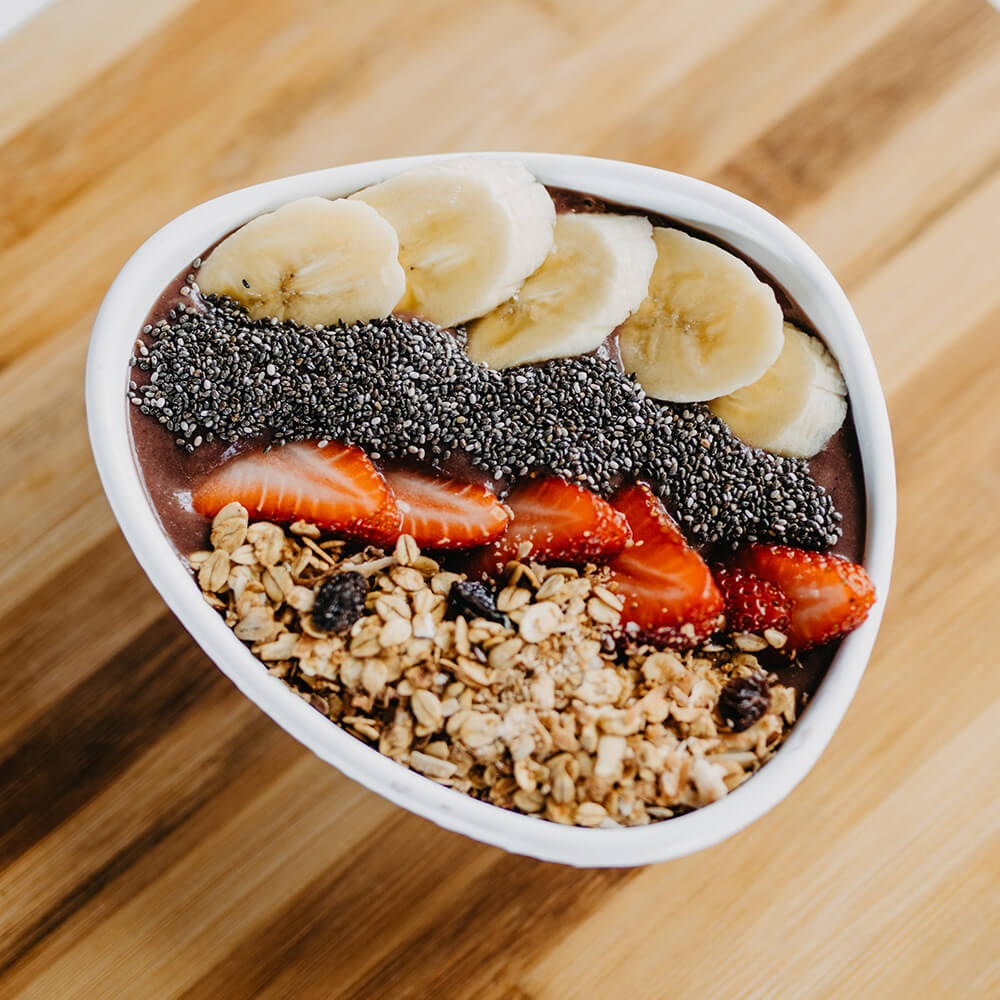 Smoothie Bowl with Apple, Strawberries, Acai, Topped with Banana, Strawberries, Chia Seeds, and Home-Made Gluten-Free Granola